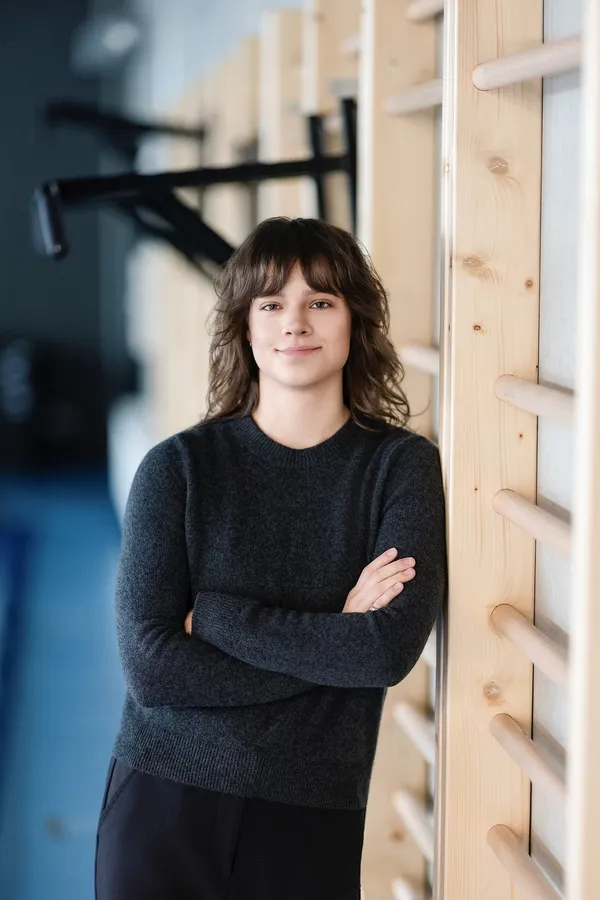 Moters portretas prie gimnastikos sienelės sporto centre