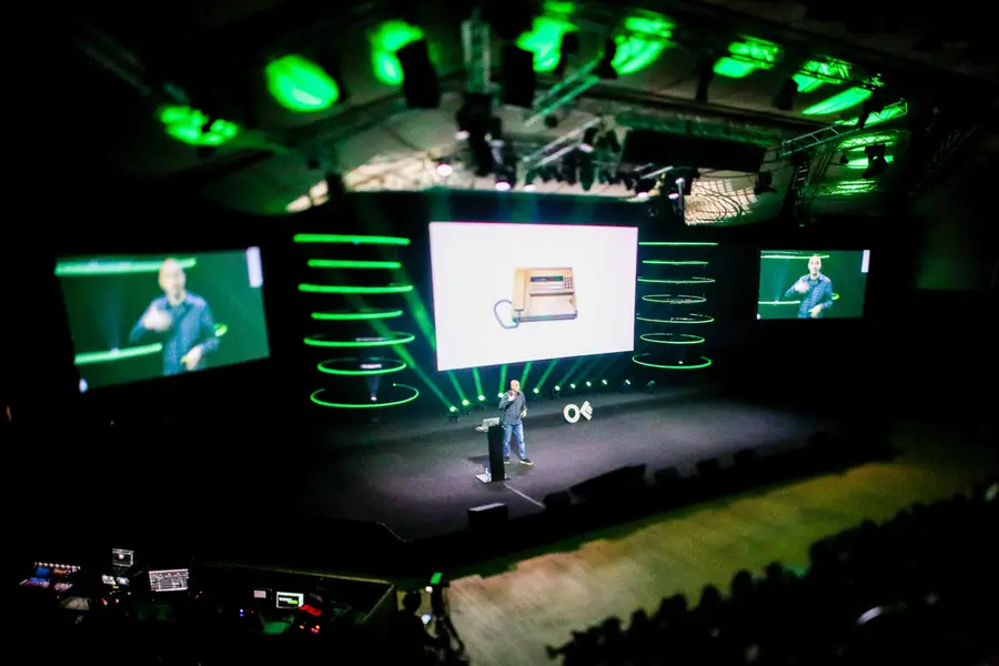 Konferencijos scena su ekranais ir žalia šviesa